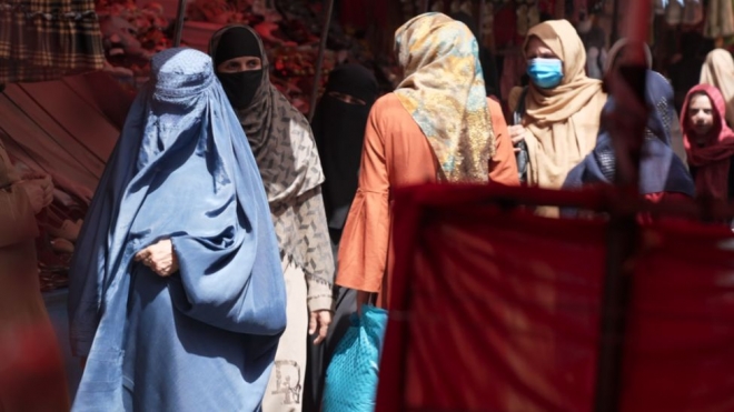 영국 BBC 특파원이 이날 카불 리시 마리암 시장을 찾았는데 눈까지 신체 모두를 가린 부르카 복장의 여성이 앞장서고 있다. BBC 홈페이지 캡처 