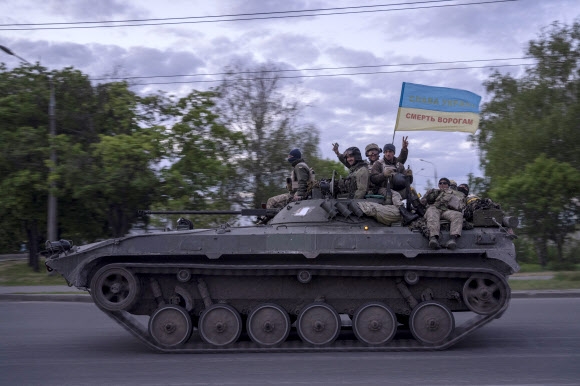 ‘탈환’ 하르키우서 국기 흔드는 우크라군 우크라이나 군인들이 16일(현지시간) 제2 도시인 동북부 하르키우(하리코프)주(州) 거리에서 장갑차를 타고 이동하며 국기를 흔들고 있다. 국기에는 ‘우크라이나에 영광을, 적에게 죽음을’이라는 문구가 쓰여 있다. 우크라이나 국방부는 이날 하르키우 전선에서 우크라이나군이 러시아군을 몰아내고 양국 국경 지대 통제권을 회복했다고 밝혔다. 2022.5.17 하르키우 AP 연합뉴스