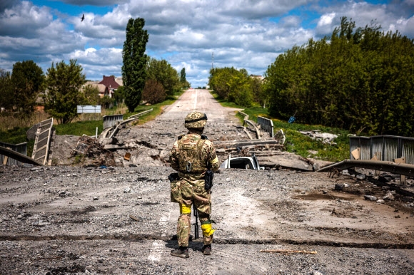 ‘러시아군 퇴각’ 하르키우서 경계 서는 우크라군 우크라이나 병사가 16일(현지시간) 하르키우(하리코프) 북쪽 루스카 로조바 마을 인근의 파괴된 다리 앞에서 경계근무를 서고 있다. 우크라이나 국방부는 이날 제2 도시인 동북부 하르키우 전선에서 우크라이나군이 러시아군을 몰아내고 양국 국경 지대 통제권을 회복했다고 밝혔다. 2022.5.17 루스카 로조바 AFP 연합뉴스