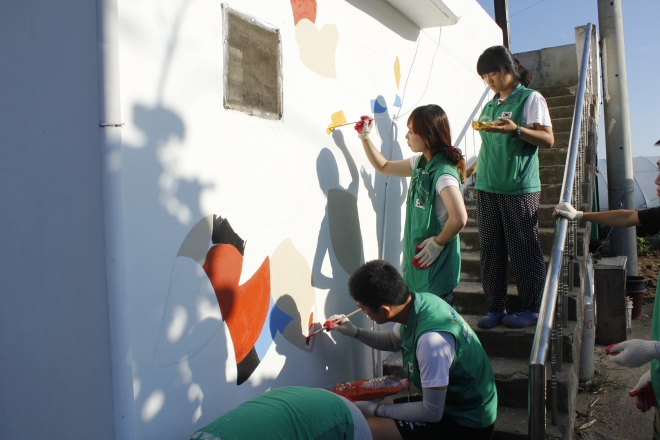 새마을운동 조끼를 입은 대학생들이 벽화 그리기 봉사를 하고 있다. 새마을중앙회 제공