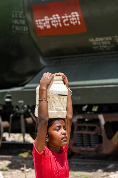 땀흘리며 물을 기르는 소녀 인도가 올해 들어 120년만의 더위를 맞았고, 시민들은 식수 부족에 시달리고 있다. AFP연합뉴스