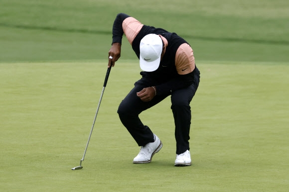 22일(한국시간) 미국 오클라호마주 털사 서던힐스 컨트리클럽에서 진행되고 있는 PGA 챔피언십에 참가한 타이거 우즈가 그린 상태를 점검하고 일어나고 있다. 오클라호마 AFP 연합뉴스   