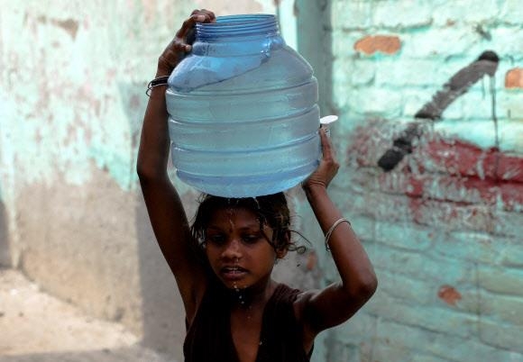 아시아, 유럽, 북미에 때 이른 폭염이 찾아오면서 전력난 우려가 커지고 있다. 지난 17일(현지시간) 인도 뉴델리의 한 소녀가 물을 채운 플라스틱 통을 머리에 이고 있다. 뉴델리 로이터 연합뉴스