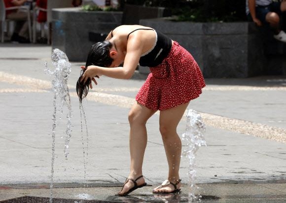 한 여성이 21일 스페인 코르도바의 분수대에서 더위를 식히고 있다. 코르도바 로이터 연합뉴스