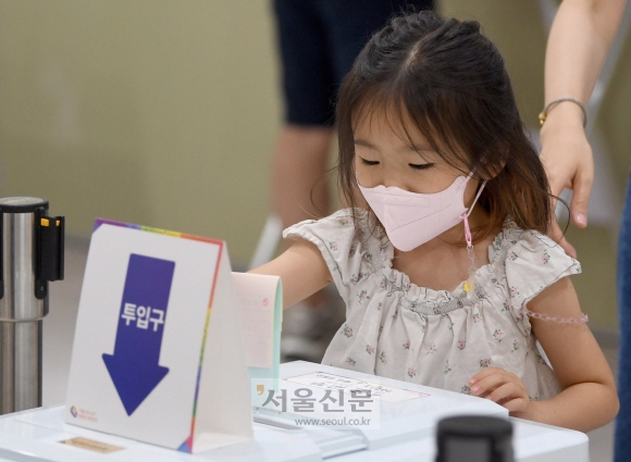 1일 서울 송파구 책박물관에 마련된 6.1 지방선거 투표소애서 어린이가 어머니를 대신해 투표를 하고 있다. 2022.06.1 박지환 기자