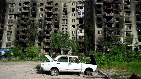 러시아군이 장악한 우크라이나 동남부 항구도시 마리우폴의 파괴된 주택 건물 앞에 파손된 차량이 버려져 있다. 2022.5.31. AFP 연합뉴스