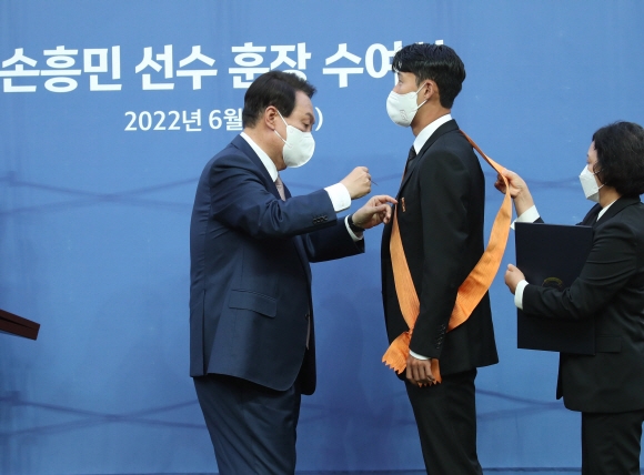 윤석열 대통령이 2일 서울월드컵경기장에서 2002 한일월드컵 20주년 기념 평가전 대한민국-브라질의 경기에 앞서 잉글랜드 프로축구 프리미어리그(EPL)에서 아시아 선수 최초로 득점왕을 차지한 손흥민에게 체육훈장 최고등급인 청룡장을 수여하고 있다. 2022.6.2  박지환 기자