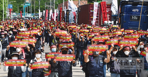 민주노총 공공운수노조 화물연대 소속 조합원들이 7일 경기 의왕 내륙컨테이너기지(ICD) 앞에서 피켓을 들고 총파업 출정식을 하고 있다. 화물연대 소속 2만 5000여명의 조합원은 전국 주요 물류 거점 16곳에서 출정식을 열고 안전운임 일몰제 폐지, 안전운임제 확대, 고유가에 따른 운송료 인상 등을 요구하는 무기한 파업에 돌입했다. 안주영 전문기자