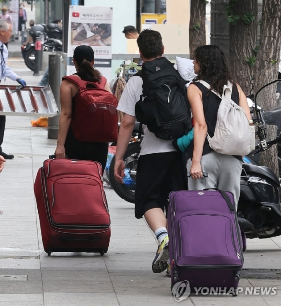 29일 외국인 밀집 지역인 서울 용산구 이태원 거리에서 여행가방을 든 외국인들이 지나가고 있다.