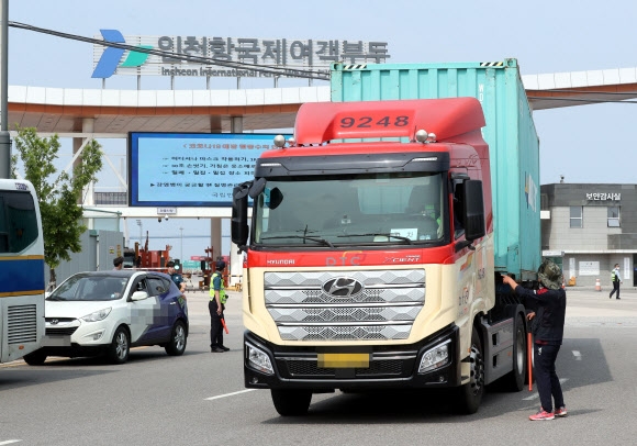 화물연대 총파업 이틀째인 8일 오전 인천시 연수구 인천항 신국제여객터미널 화물터미널 입구에서 화물연대 인천지역본부 조합원들이 비조합원의 트럭을 세운 뒤 운송을 멈춰 총파업에 힘을 보태달라고 요청하고 있다. 2022.6.8 연합뉴스