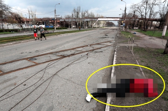 우크라이나 남부 도시 마리우폴에 있는 일리치 철강공장 근처 도로 가에 4월 15일(현지시간) 민간인 희생자의 시신이 아무렇게 방치돼 있다.마리우폴 로이터 연합뉴스