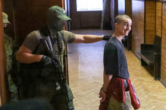 9일(현지시간) 우크라이나 동부 도네츠크에서 러시아군에 사로잡힌 영국인 2명과 모로코인 1명이 친러시아 반군 정부인 도네츠크인민공화국(DPR) 법원의 철창에 갇혀있다. 우크라이나군에 가담해 전투에 참가했다가 투항한 이들 3명은 법원에서 사형 선고를 받았다.타스연합뉴스