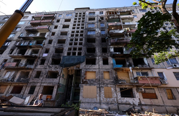 10일(현지시간) 우크라이나의 수도 키이우의 북쪽 외곽의 폭격 피해 아파트에서 한 주민이 완전히 파괴된 건물 앞에 서 있다. 이 아파트는 지난 3월 14일 러시아군의 폭격으로 극심한 피해를 본 곳으로 사상자가 다수 발생한 곳이다. 러시아의 우크라이나에 대한 공격이 동남부 돈바스 지역에 집중되면서 전쟁을 피해 키이우를 떠났던 시민들이 집으로 돌아오고 있지만, 폭격 피해지역의 주민들은  부서진 집에서 쓸 수 있는 가재도구만 수습하고 있다. 2022.6.11 연합뉴스