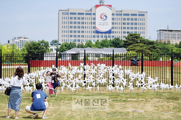 서울 용산공원 부지가 일반 국민에게 시범 개방되고 맞은 첫 주말인 12일 현장을 찾은 방문객이 대통령 집무실을 배경으로 기념 촬영을 하고 있다. 박윤슬 기자