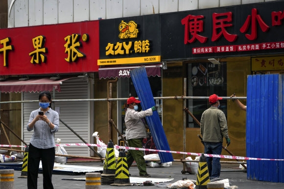 중국 베이징에서 도시 집단 감염이 다시 시작된 12일 시내 식당들이 밀집된 거리에 코로나19 추가 확산을 막고자 주민 전급을 차단하기 위한 장벽이 설치되고 있다. 베이징 AP 연합뉴스 