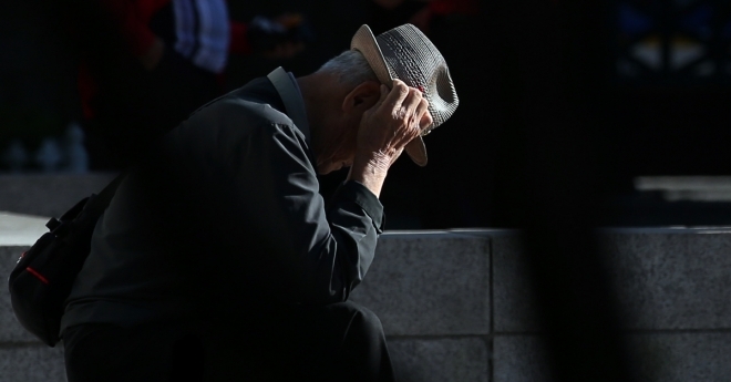 사진은 한 노인이 서울 종로구 탑골공원에서 계단에 앉아 머리를 감싸고 있는 모습. 연합뉴스