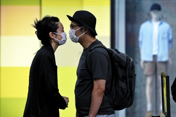 중국의 수도 베이징에서 봉쇄를 풀자마자 코로나19가 다시 퍼지기 시작한 가운데 13일 시내의 코로나 검사소 앞에서 한 커플이 대기 중 서로를 마주보고 있다. 베이징 AP 연합뉴스