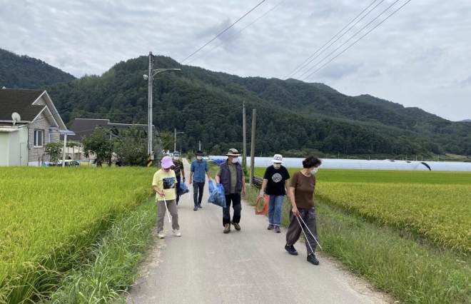 강원도 양구의 은퇴자 공동체 마을 입주자들이 동네를 산책하며 쓰레기를 줍는 플로깅에 참여하고 있다.