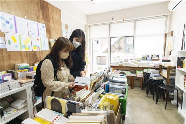 서울 마포구에 있는 독립서점 ‘헬로인디북스’ 내부 풍경. 20대 여성 손님들이 책을 들여다보고 있다. 류재민 기자