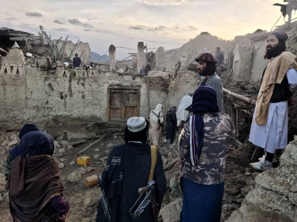 아프가니스탄 사람들이 22일 새벽 동부 팍티카 지방을 덮친 규모 6.1의 지진 때문에 무너진 주택 더미를 바라보며 망연자실하고 있다. 박타르 통신 제공 AP 연합뉴스