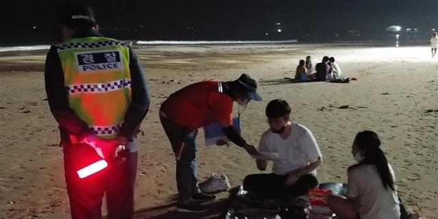 코로나19 발생 첫해인 2020년 7월 대천해수욕장 백사장에서 야간 취식을 하던 피서객을 단속반이 적발해 이동을 요청하고 있다. 서울신문 DB