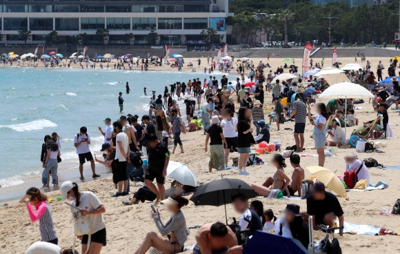 초여름 무더위가 덮친 지난 19일 시범 운영에 들어간 해운대해수욕장에 수많은 시민과 관광객이 찾아와 코로나19 이전처럼 물놀이를 즐기고 있다. 부산 뉴시스