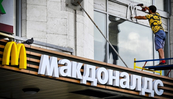 맥도날드의 러시아 사업 철수 후 모스크바의 한 매장에서 근로자가 맥도날드 로고를 제거하고 있다. 2022.6.17 AFP 연합뉴스