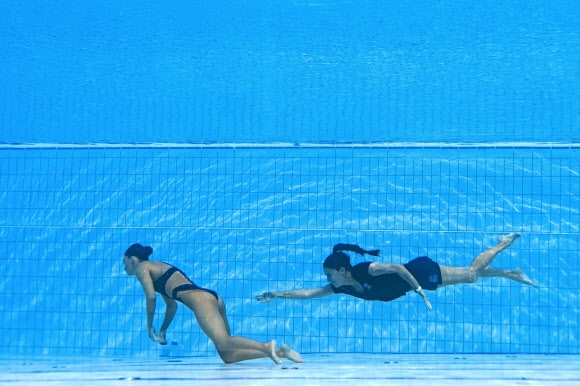 미국 아티스틱스위밍 알바레스가 물속에서 의식을 잃자 푸엔테스 코치가 물속에 뛰어 들어 구조하고 있다. AFP연합뉴스