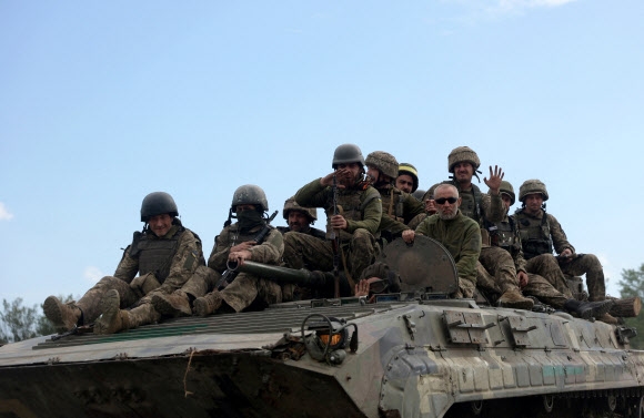 우크라이나 동부 루한스크주의 한 도로에서 우크라이나 군인들이 장갑차 위에 앉아 있다.2022.6.23 AFP 연합뉴스