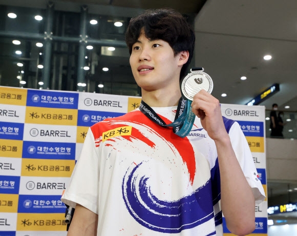 2022년 세계수영선수권 대회에서 은메달을 획득한 황선우 선수가 27일 인천국제공항 제1여객터미널로 귀국해 메달을 들어보이고 있다. 연합뉴스