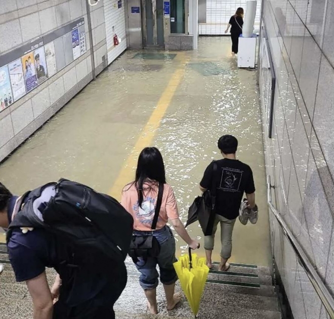 30일 오전 폭우로 물이 찬 지하통로를 건너는 시민들. 온라인커뮤니티