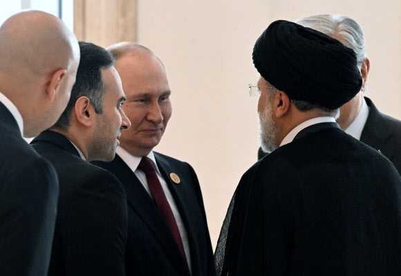 블라디미르 푸틴(왼쪽 세 번째) 러시아 대통령이 29일(현지시간) 투르크메니스탄 아시가바트의 카스피해 연안국 정상회의에서 에브라힘 라이시(오른쪽) 이란 대통령과 만나 대화를 나누고 있다. 아시가바트 EPA 연합뉴스