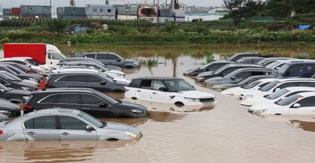많은 비가 내린 30일 경기도 수원시의 한 중고차 단지 주차장이 물에 잠겨 있다. 연합뉴스