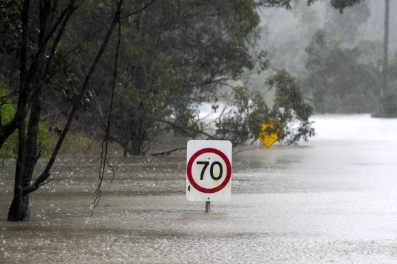 호주 시드니 외곽의 런던데리에서 물에 잠긴 도로 위로 교통 표지판이 보인다. 시드니 인근에서 18개월 만에 최악의 홍수가 발생해 주민 3만여명에 대피령이 내려졌다. 2022.7.4 AP 연합뉴스