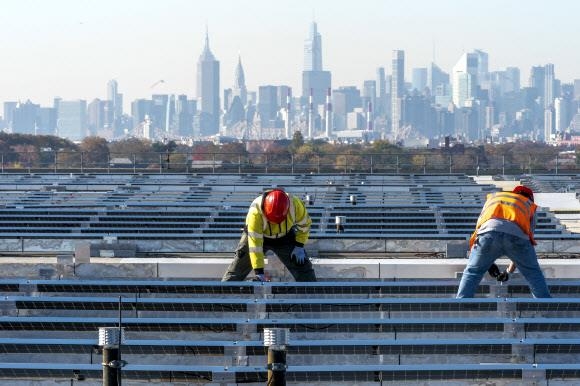 지난해 9월 미국 뉴욕 라과디아 공항의 옥상에 태양광 발전 패널을 설치하는 모습. 태양광, 풍력 등 신재생에너지만으로 전력 수요를 감당하기 힘들어지자 조 바이든 행정부는 탈원전 기조를 바꾸고 있다. 뉴욕 AP