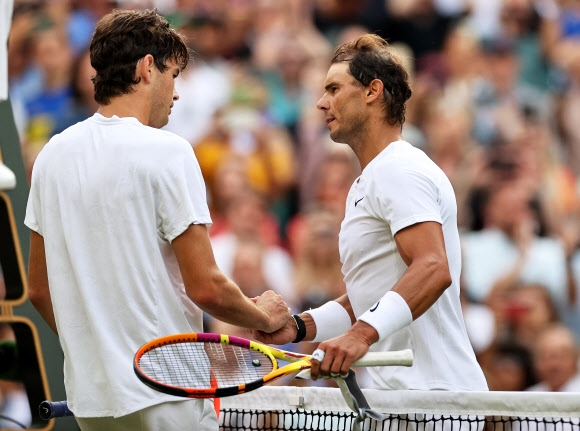 라팔엘 나달(오른쪽)이 7일 윔블던 테니스대회 남자단식 8강전에서 3-2승을 거두고 자신의 31번째 메이저 결승행에 한 발만을 남긴 뒤 패자 테일러 프리츠를 위로하고 있다. [EPA 연합뉴스]