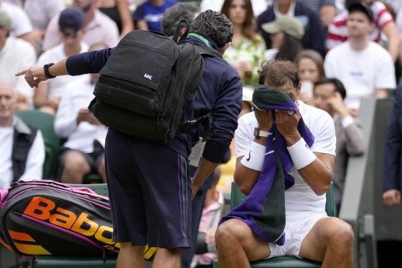 라팔엘 나달(오른쪽)이 7일 윔블던 테니스대회 남자단식 8강전 2세트 도중 메디컬 타임아웃을 요청한 뒤 의료진의 조언을 듣고 있다.[AP 연합뉴스]