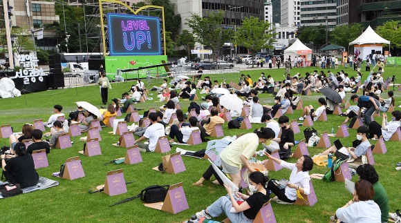7일 서울시청 광장에서 열린 참신한 북 콘서트에서 시민들이 잔디에 종이의자와 돗자리를 펴고 콘서트 참여를 하고 있다. 2022.7.7 오장환 기자