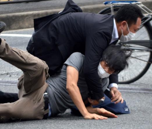 8일 일본 나라현 나라시 야마토사이다이지역 앞에서 참의원 선거 유세활동을 하던 아베 신조 전 일본 총리를 총기로 저격한 용의자 야마가미 데쓰야(아래)가 범행 직후 제압당하고 있다. 로이터 연합뉴스