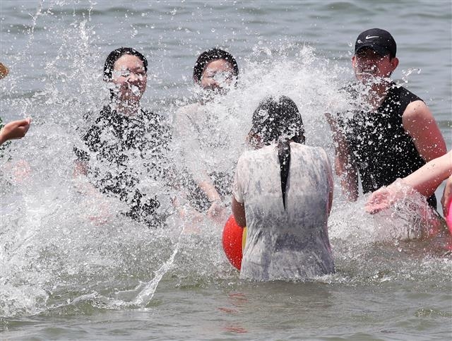 ‘더위야 물러가라’ 폭염이 기승을 부린 9일 인천 중구 을왕리해수욕장을 찾은 시민들이 물놀이를 하며 더위를 식히고 있다. 2022.7.9 뉴스1