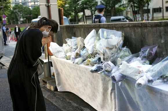 한 일본인이 10일 자민당 청사 입구 근처에서 아베 신조 전 총리의 죽음을 추모하고 있다. 도쿄 AP 연합뉴스