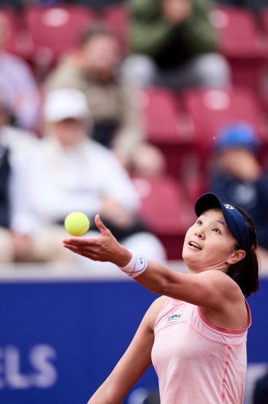 장수정(대구시청)이 지난 9일(한국시간) 스웨덴 베스타드에서 열린 여자테니스협회(WTA) 노디아오픈 단식 결승전에서 리베카 마사로바(스페인)에게 서브를 넣기 위해 공을 위로 토스하고 있다. 이날 마사로바를 2-1로 꺾은 장수정은 1982년 이덕희의 우승 이후 40년 만에 WTA 대회에서 우승을 차지한 한국 선수가 됐다. 작은 사진은 장수정이 테니스 공을 본 뜬 우승 트로피를 들고 환하게 웃고 있는 모습. 베스타드 AFP 연합뉴스