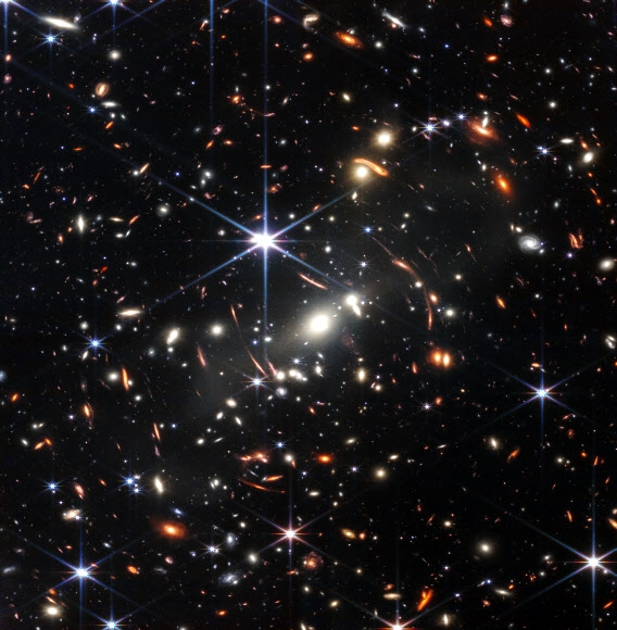 미항공우주국(NASA)이 11일(현지시간) 처음으로 공개한 제임스웹 우주망원경의 근적외선 카메라(NIRCam)가 12시간 30분 동안 촬영한 ‘SMACS 0723’ 은하단의 모습. 빛 하나가 각각의 은하이며, 은하마다 수천억 개의 별들로 구성돼 있다. 지구에서 46억 광년 떨어진 해당 은하단의 거대한 중력장이 은하단 뒤에 있는 천체의 빛을 확대·굴절시키면서 130억년 전 초기 은하의 모습까지 포착됐다. 미항공우주국 제공