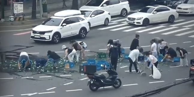 인천 남동구 만수동 한 사거리에 쏟아진 소주병을 시민들이 자발적으로 나서서 치우고 있다. 유튜브 영상 캡처