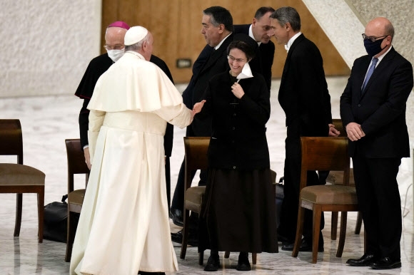 프란치스코 교황이 13일(이하 현지시간) 사상 처음으로 주교부에서 일할 여성 세 명을 임명했다. 사진은 지난해 12월 23일 시청 직원들과 간담회에 도착한 교황이 이번에 임명된 세 여성 가운데 가장 고위직이었던 라파엘라 페트리니 바티칸 시청 사무총장과 손을 맞잡으며 인사하는 모습. AP 자료사진 연합뉴스 