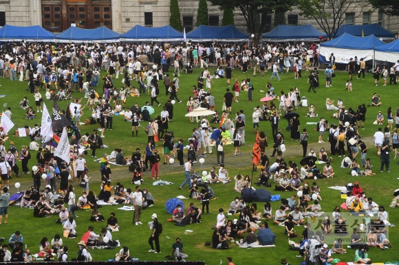 16일 서울광장에서 열린 퀴어문화축제 참가자들이 잔디에 앉아 행사를 즐기고 있다. 안주영 전문기자