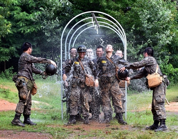 충남 논산 육군훈련소에서 훈련을 마친 훈련병들이 샤워터널을 지나며 더위를 식히고 있다. 육군훈련소 제공