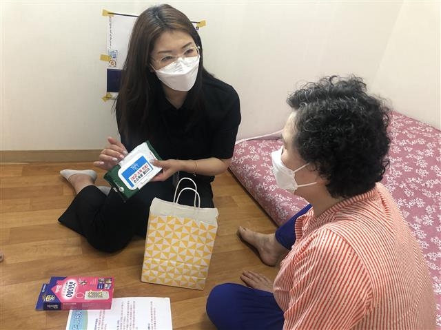 서울 중랑구 치매안심센터 관계자가 치매안심마을에 거주하는 어르신에게 치매안심키트를 전달하고 있다. 중랑구 제공
