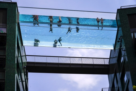 하늘 위 풀장은 천국  18일(현지시간) 영국 런던 옥외 수영장인 ‘스카이 풀’에서 시민들이 수영을 즐기고 있다. 런던 AP 연합뉴스