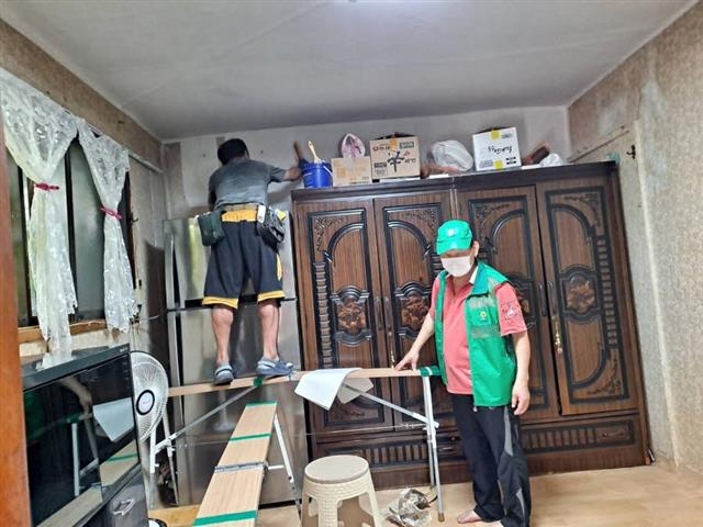 서울 성북구 장위3동 새마을지도자협의회 회원들이 한 주민의 집에서 오래된 벽지를 교체하고 있다. 성북구 제공